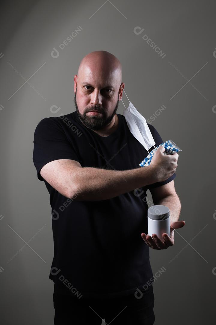 homem careca com camiseta preta usando máscara protetora