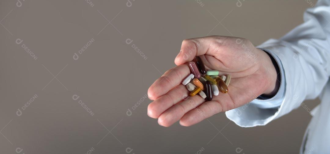 Mão de médico de medicina masculina segurando e oferecendo pílulas e vitamina