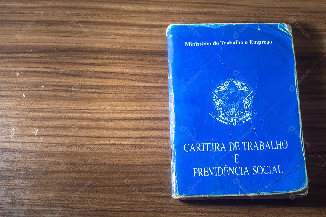República Federativa do Brasil, Ministério do Trabalho. Carteira de trabalho ao lado de moedas reais brasileiras