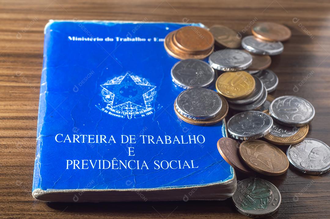 República Federativa do Brasil, Ministério do Trabalho. Carteira de trabalho ao lado de moedas reais brasileiras