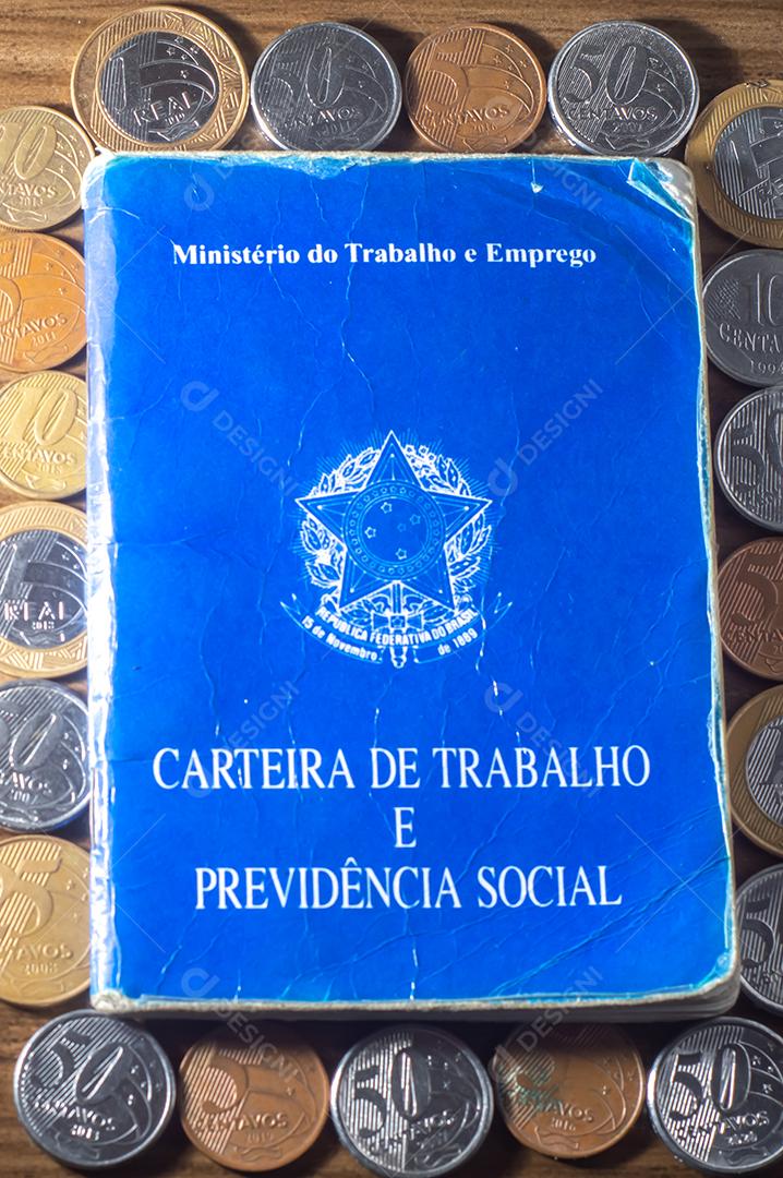 República Federativa do Brasil, Ministério do Trabalho. Carteira de trabalho ao lado de moedas reais brasileiras