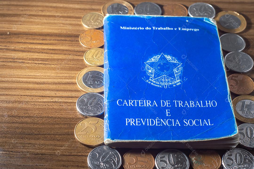 República Federativa do Brasil, Ministério do Trabalho. Carteira de trabalho ao lado de moedas reais brasileiras