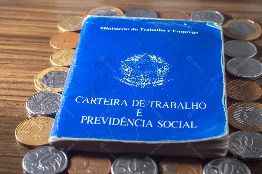 República Federativa do Brasil, Ministério do Trabalho. Carteira de trabalho ao lado de moedas reais brasileiras