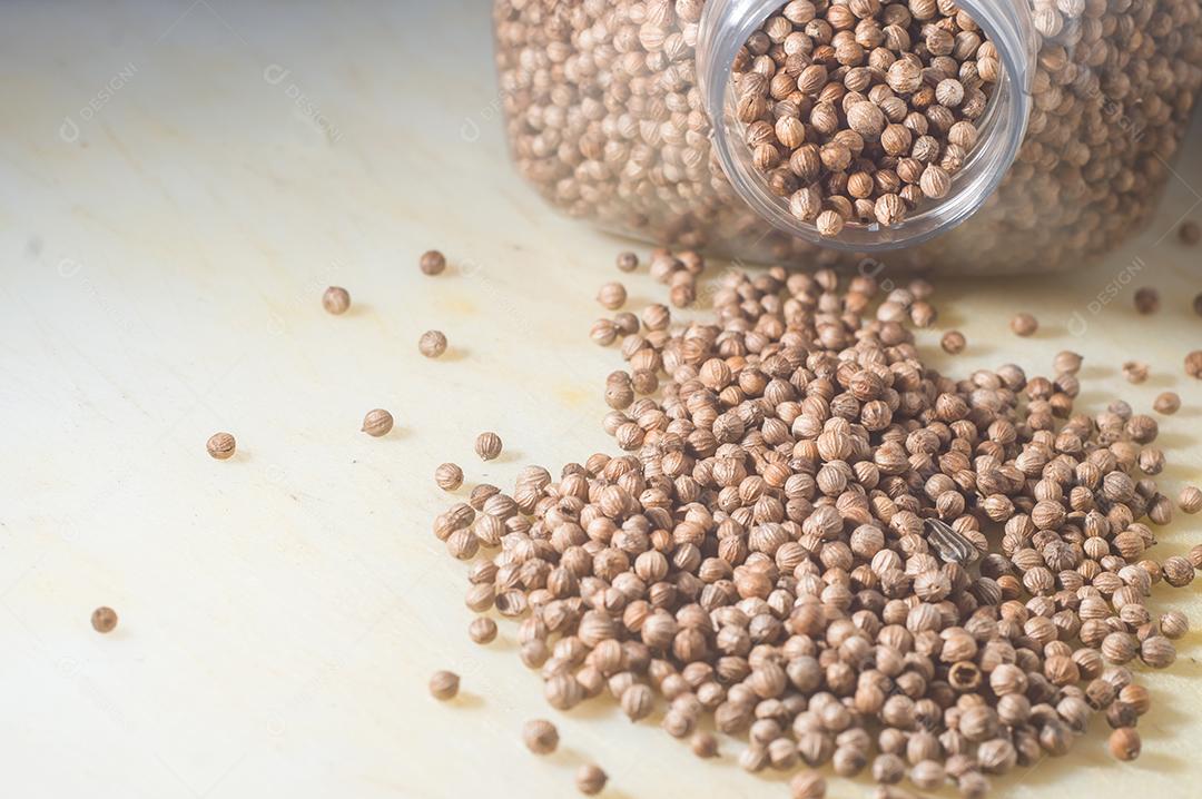 Coentro sementes de coentro em um quadro branco com e garrafa cheia de sementes