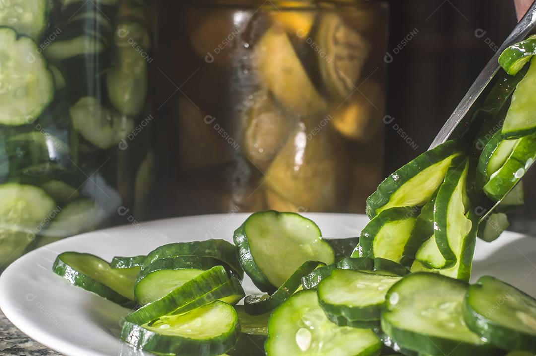Picles de pepino em um prato branco com fundo escuro