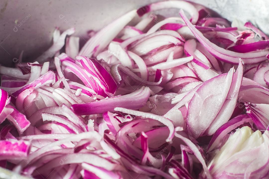 cebola roxa em uma panela de alumínio, rua ao fundo