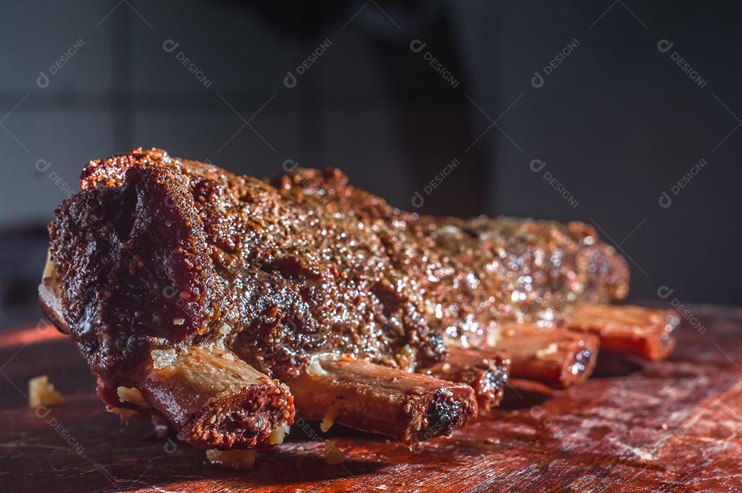 Costeletas de churrasco de verão grelhadas picantes servidas com uma tábua de madeira vintage antiga