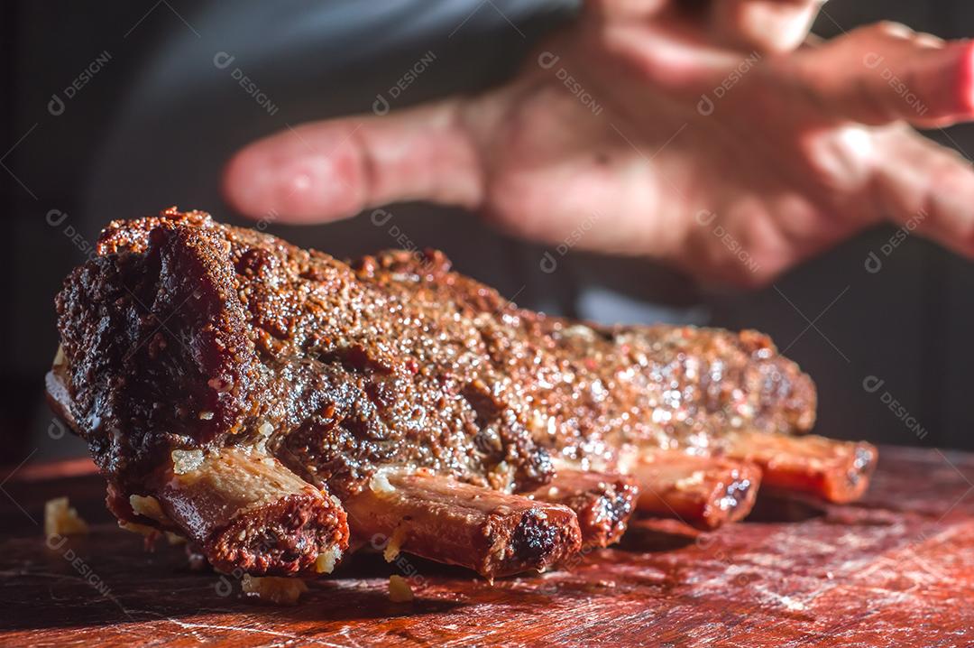 Costeletas de churrasco de verão grelhadas picantes servidas com uma tábua de madeira vintage antiga