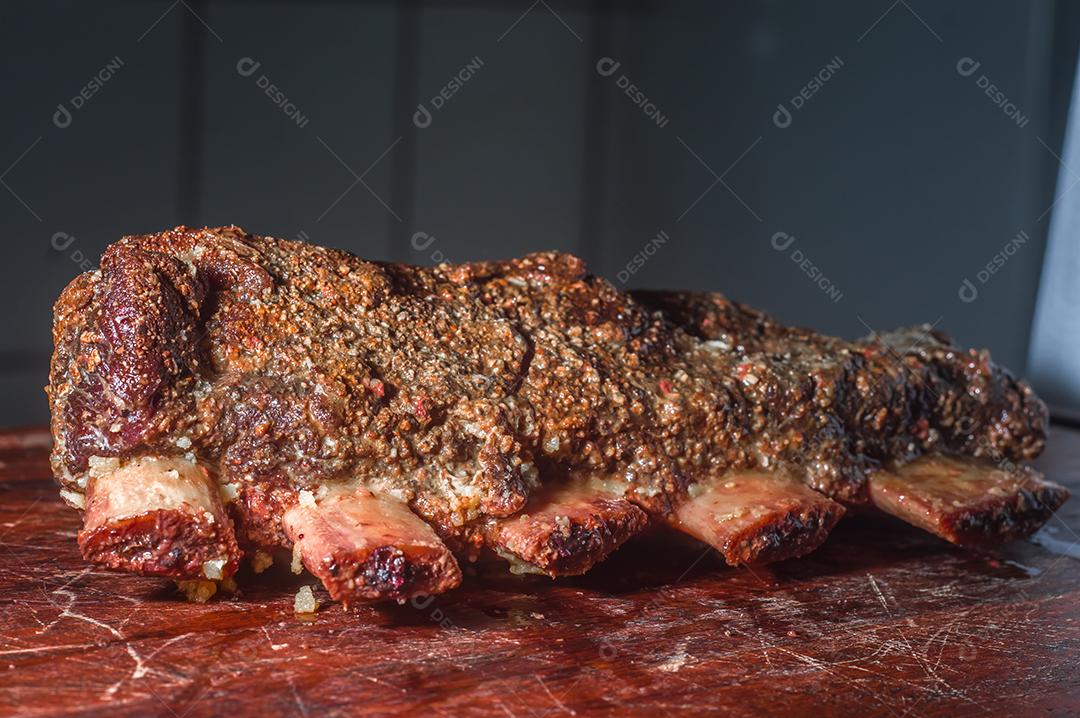 Costeletas de churrasco de verão grelhadas picantes servidas com uma tábua de madeira vintage antiga