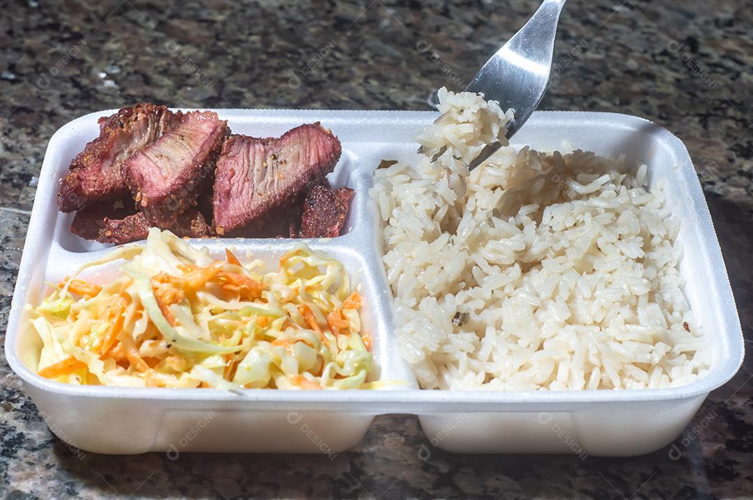 Entregue comida, marmite ou marmitex executivo com carne de arroz e salada de repolho.