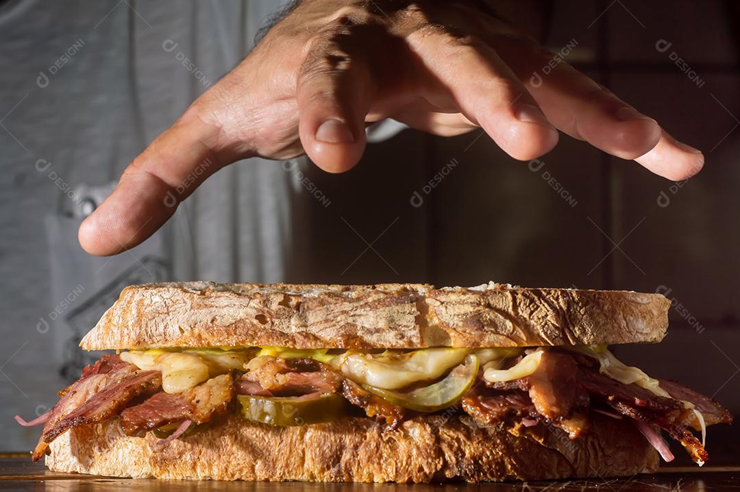 Sandwhich pastrami em uma tábua de madeira com delicioso encontro no pão baguete com queijo