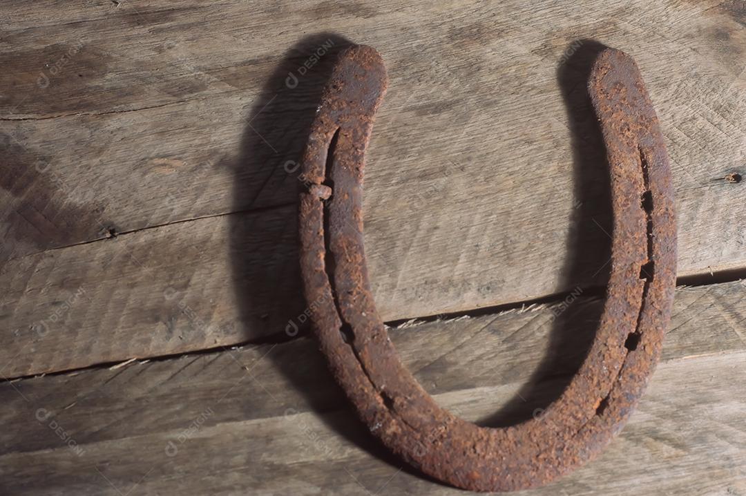 Ferradura de cavalo com fundo de madeira e luz natural, copie o espaço em partes da imagem, conceito de fazenda.
