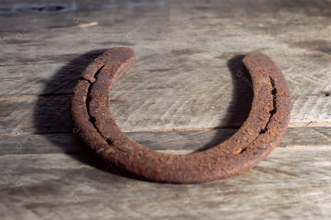 Ferradura de cavalo com fundo de madeira e luz natural, copie o espaço em partes da imagem, conceito de fazenda.