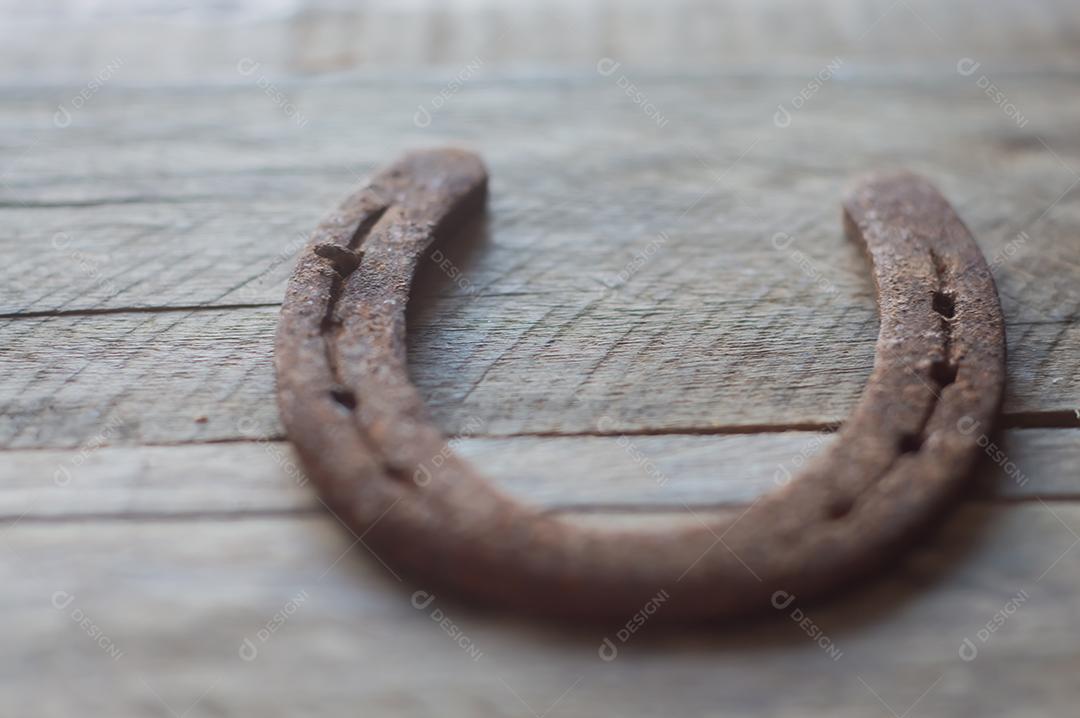 Ferradura de cavalo com fundo de madeira e luz natural, copie o espaço em partes da imagem, conceito de fazenda.