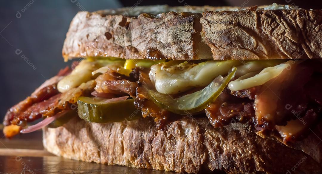 Sandwhich pastrami em uma tábua de madeira com delicioso encontro no pão baguete com queijo