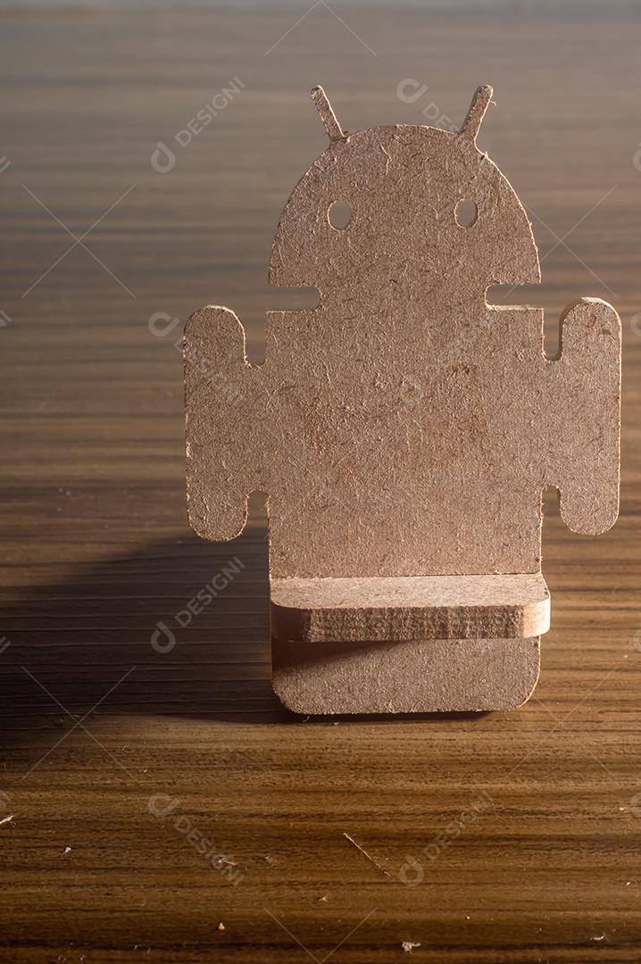 Android feito de madeira MDF, colocado em uma mesa de madeira