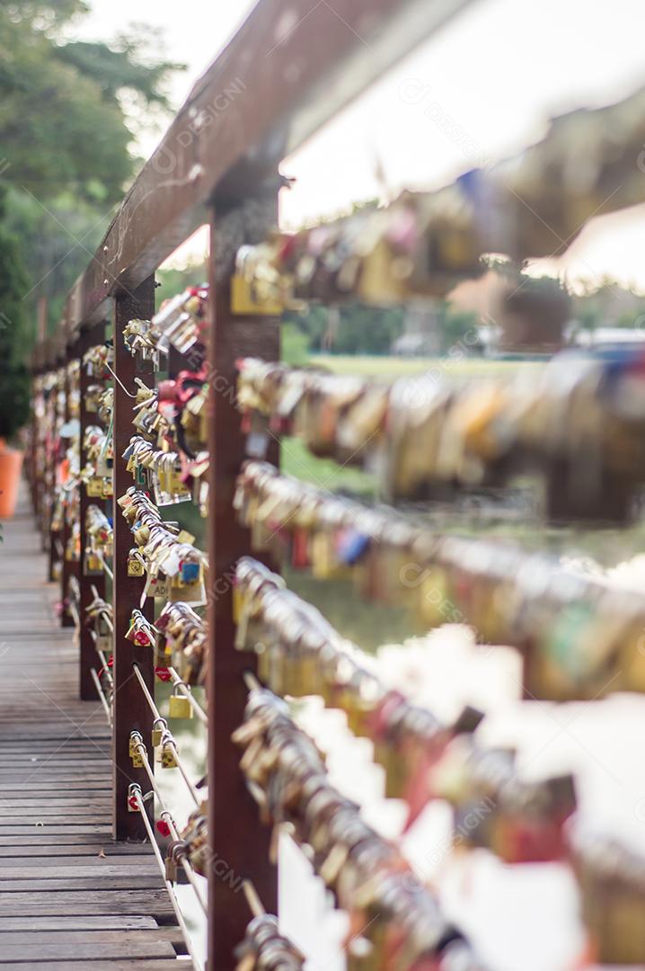 Ponte de madeira com cadeados acoplados, centenas de cadeados