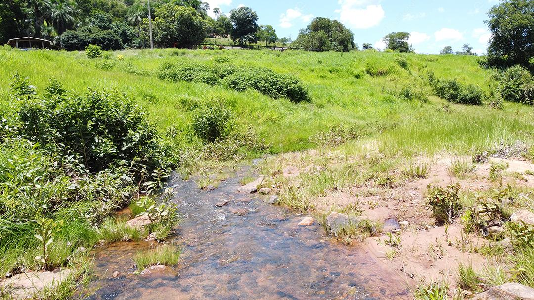 Drone sobrevoado pequeno córrego em uma fazenda