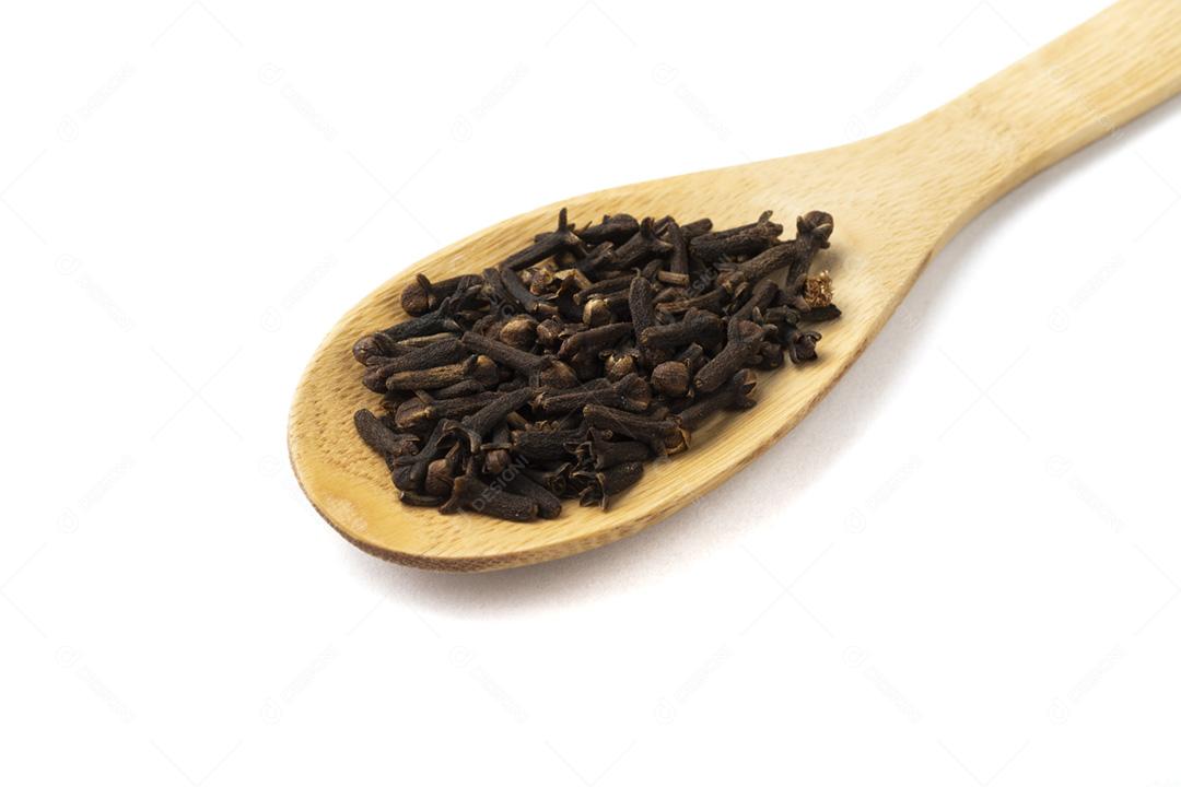 Closeup de cravo em uma colher de pau isolada sobre backgrou branco