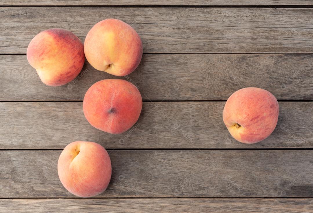 Um grupo de pêssegos sobre a mesa de madeira