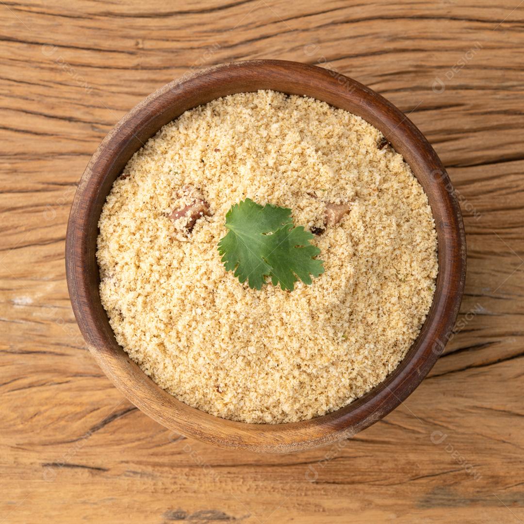 Farofa, acompanhamento típico de farinha de mandioca brasileira sobre aba de madeira