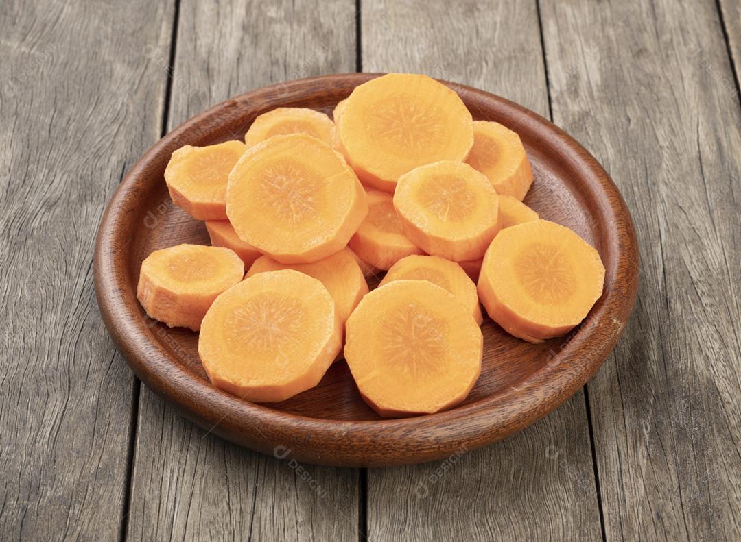 Fatias de cenoura em um prato sobre a mesa de madeira