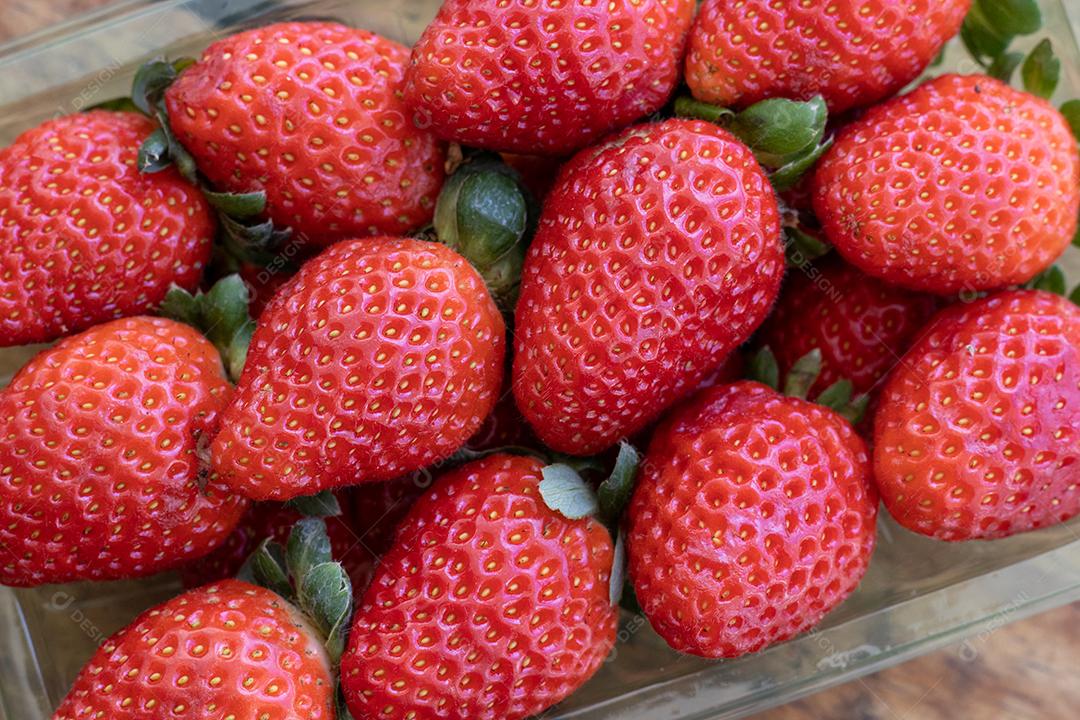 Vários morangos em forma de verde sobre uma mesa de madeira