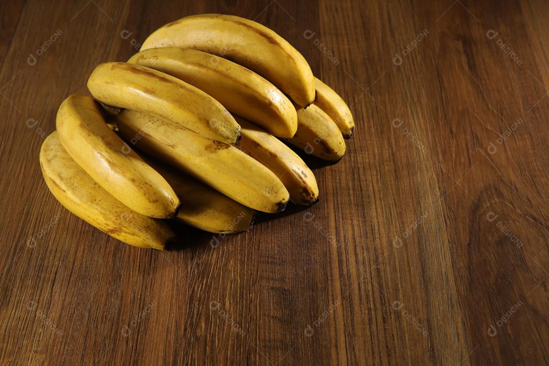 banquete de bananas amarelas maduras em fundo de madeira