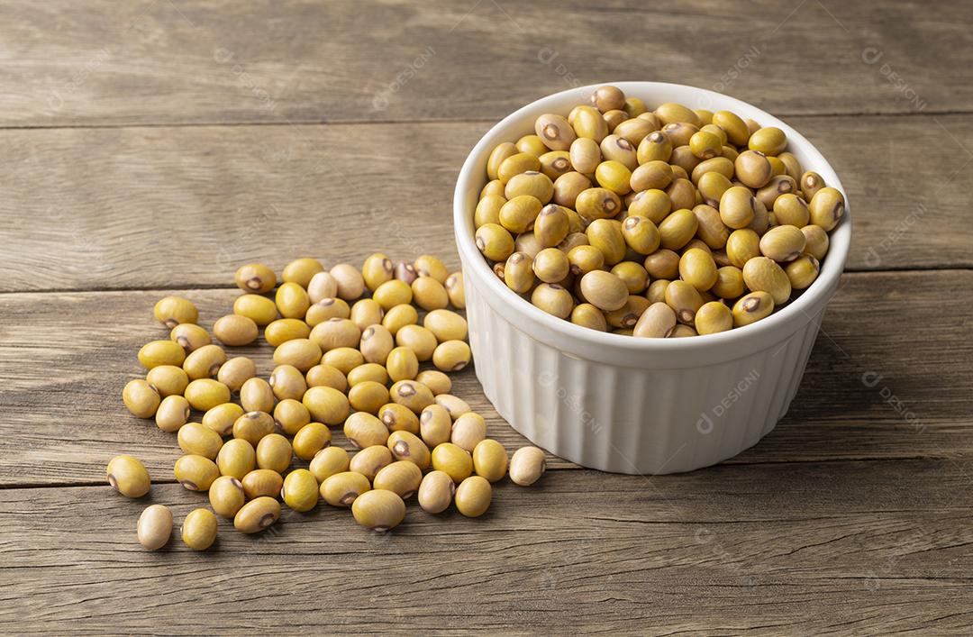 Feijão amarelo em uma tigela sobre a mesa de madeira.