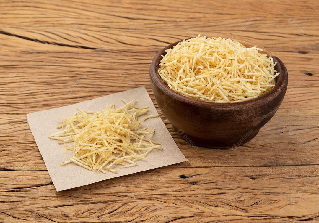 Batata palha ou batata palha em uma tigela sobre a mesa de madeira.