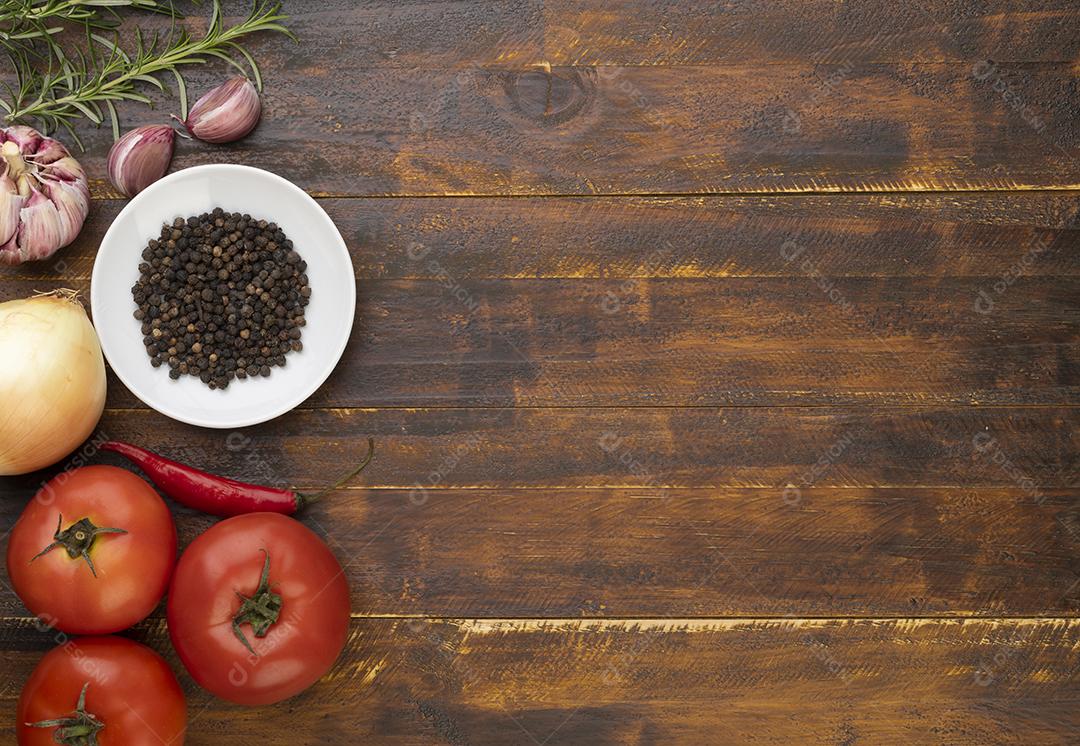 Tomate, alho, pimentão e ervas sobre a mesa de madeira