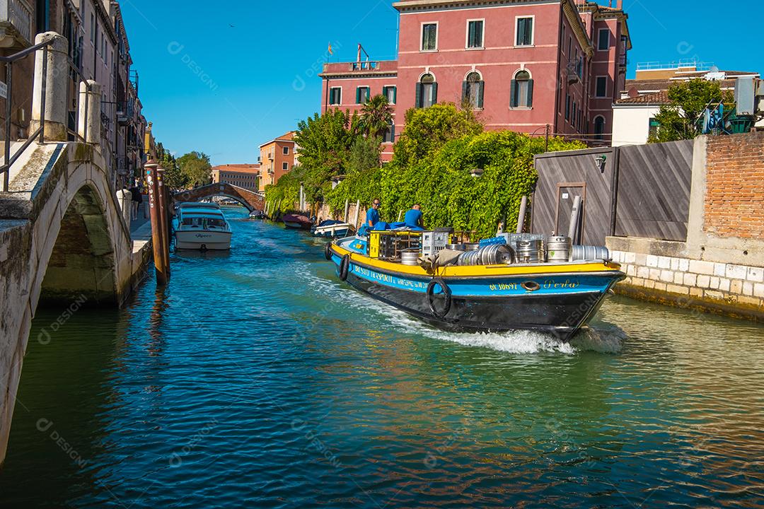Vista de barcos transportando produtos para abastecer a população nos canais de veneza, itália.