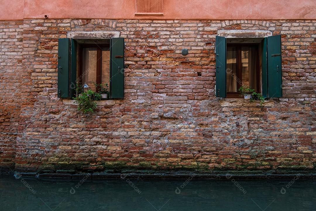 Janelas de casas tradicionais nos canais de Veneza vistas através dos becos