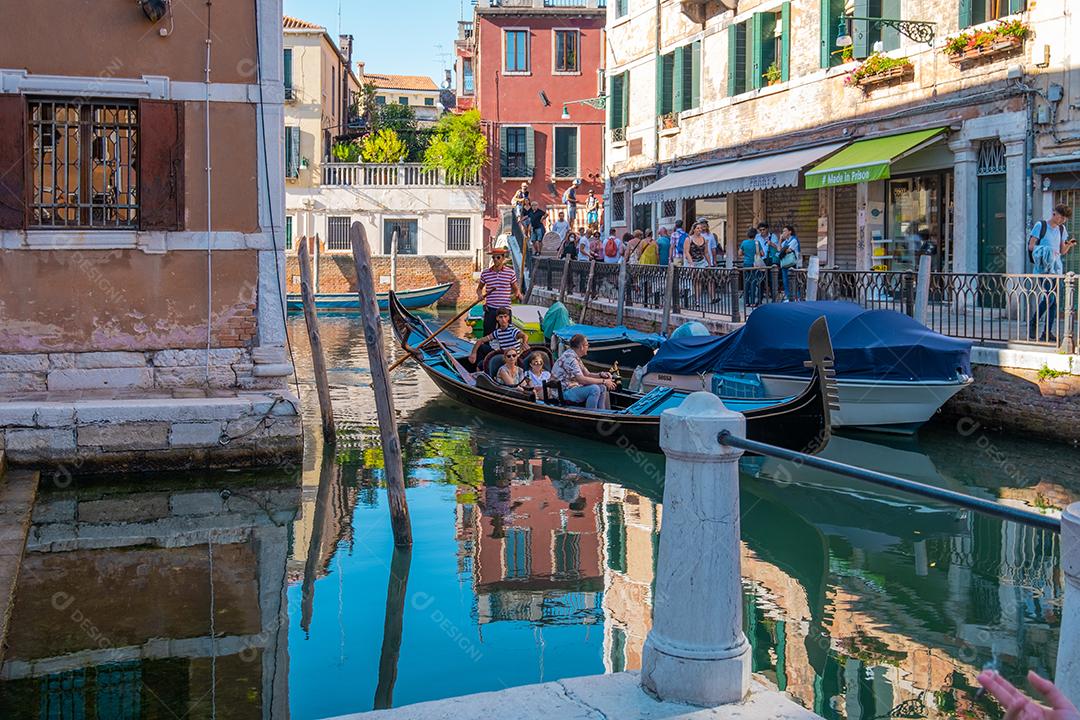 Vista de turistas nas ruas e gôndolas pelos canais de Veneza.