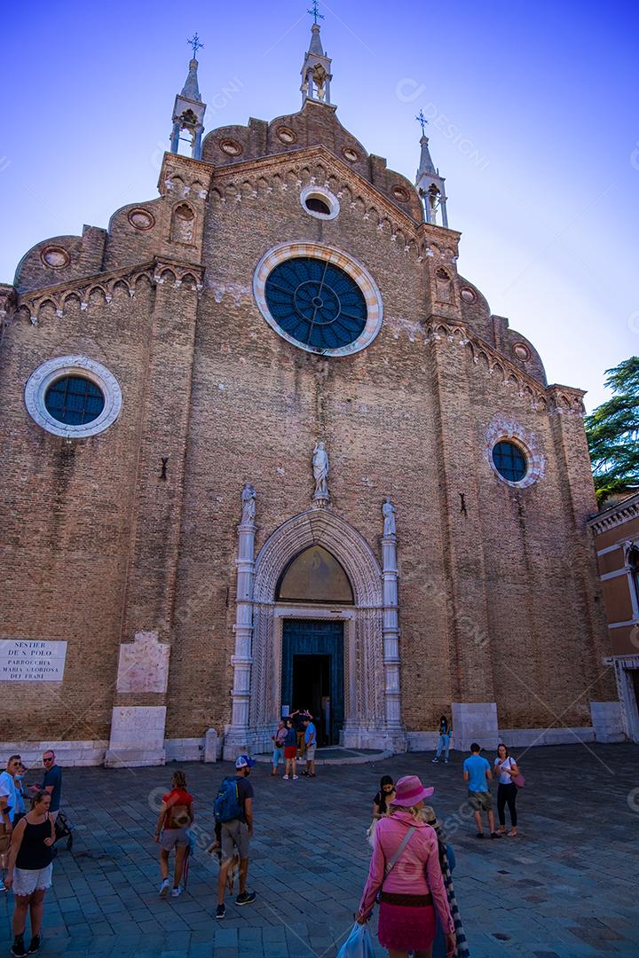 Antiga igreja nas ruas de Veneza com pessoas andando.