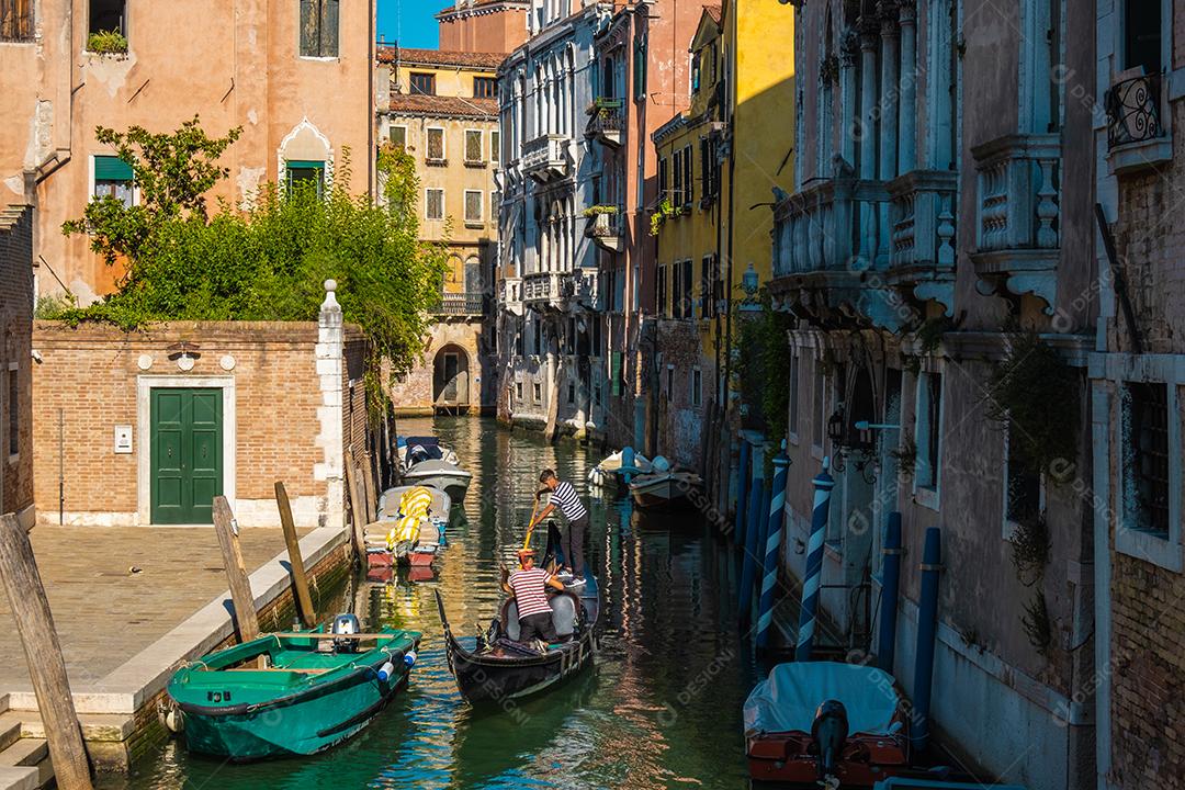 Gôndola navegando em canais típicos de água veneziana.