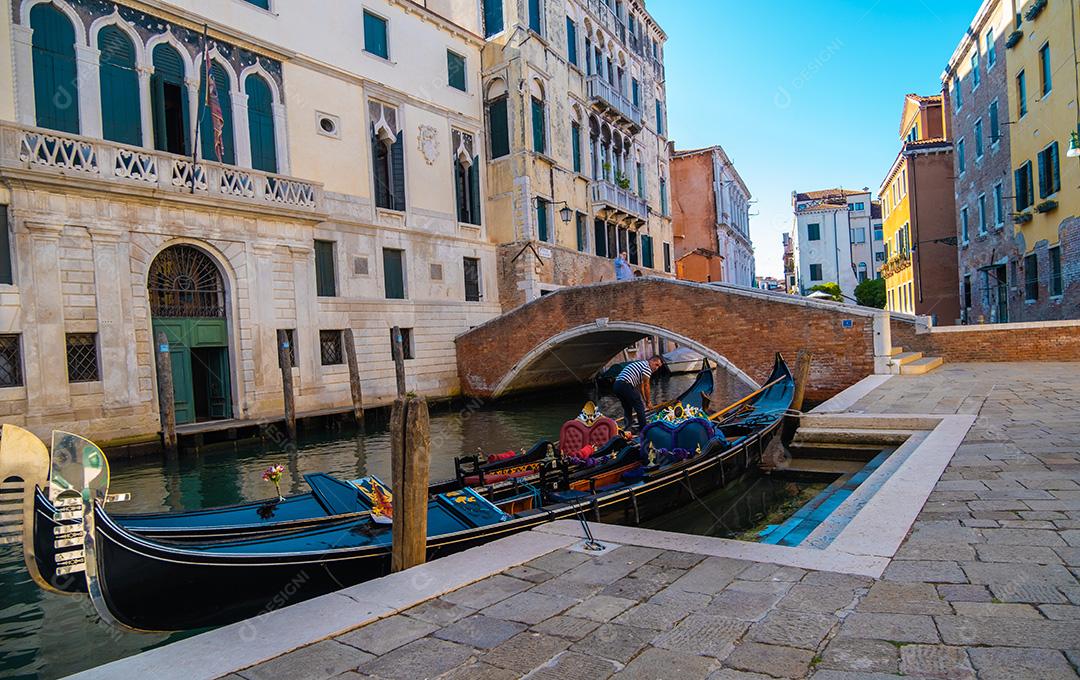 Vista do gondoleiro esperando clientes em canais vazios e veneza em pandemia.