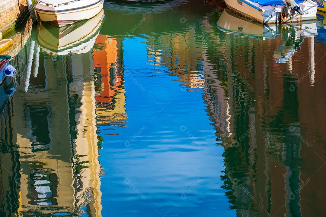 Céu e barcos refletindo nas águas dos canais vazios de Veneza