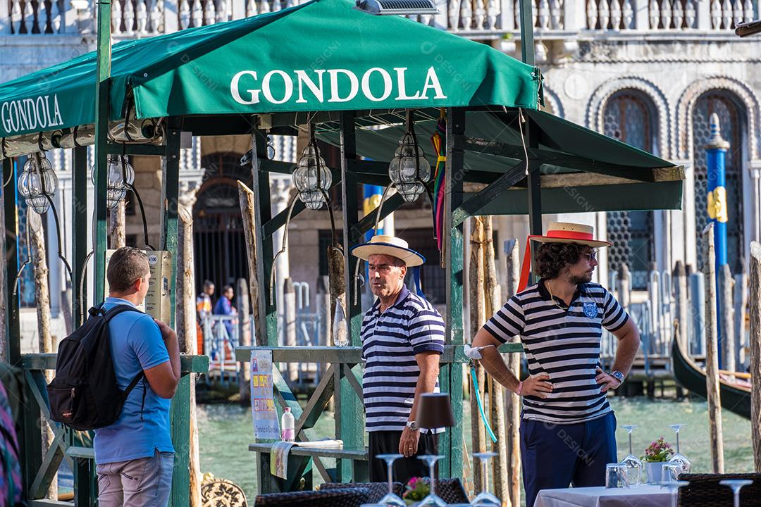 Gondoleiros negociando com um turista nos canais de Veneza na Itália.