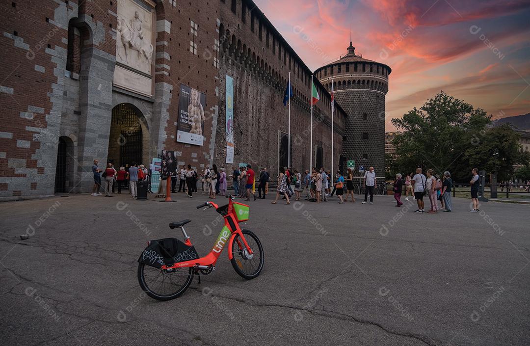 Muralha exterior do Castelo Sforza (Castello Sforzesco) e torre de esquina com partilha de bicicletas em primeiro plano.