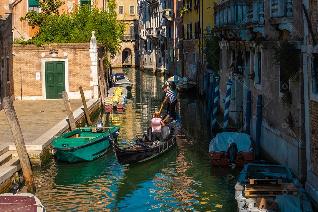 Gôndola navegando em canais típicos de água veneziana.