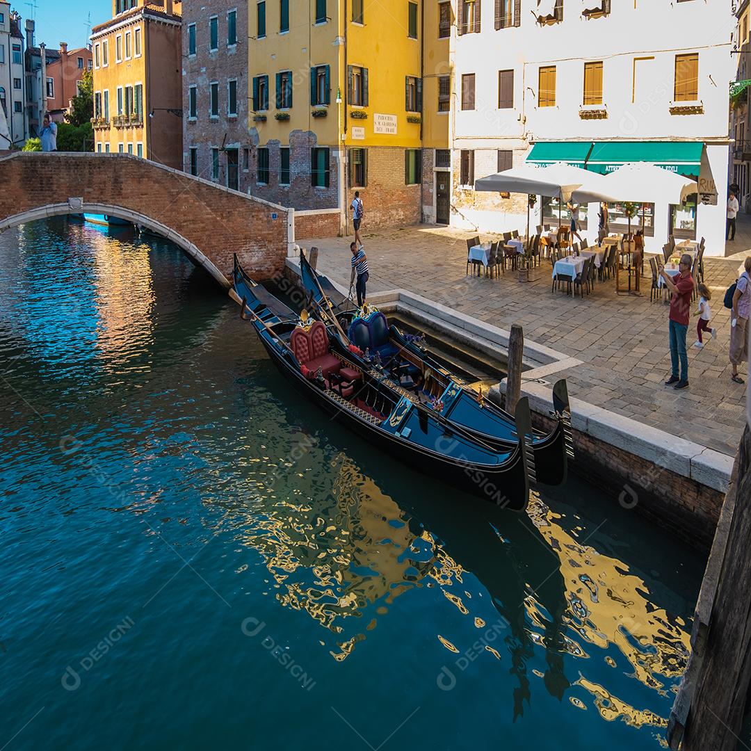 Vista do gondoleiro esperando clientes em canais vazios e veneza em pandemia.