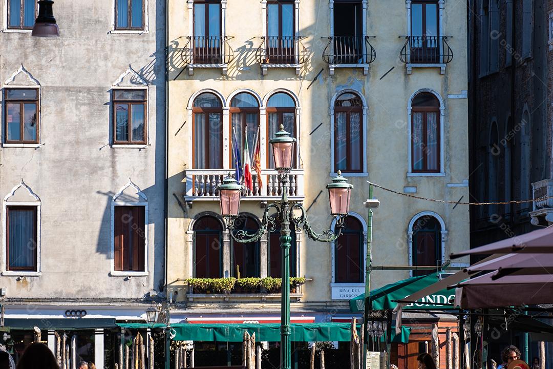 Poste de luz típico de Veneza com prédio antigo no fundo.