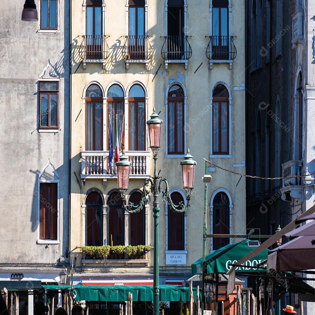 Poste de luz típico de Veneza com prédio antigo no fundo.