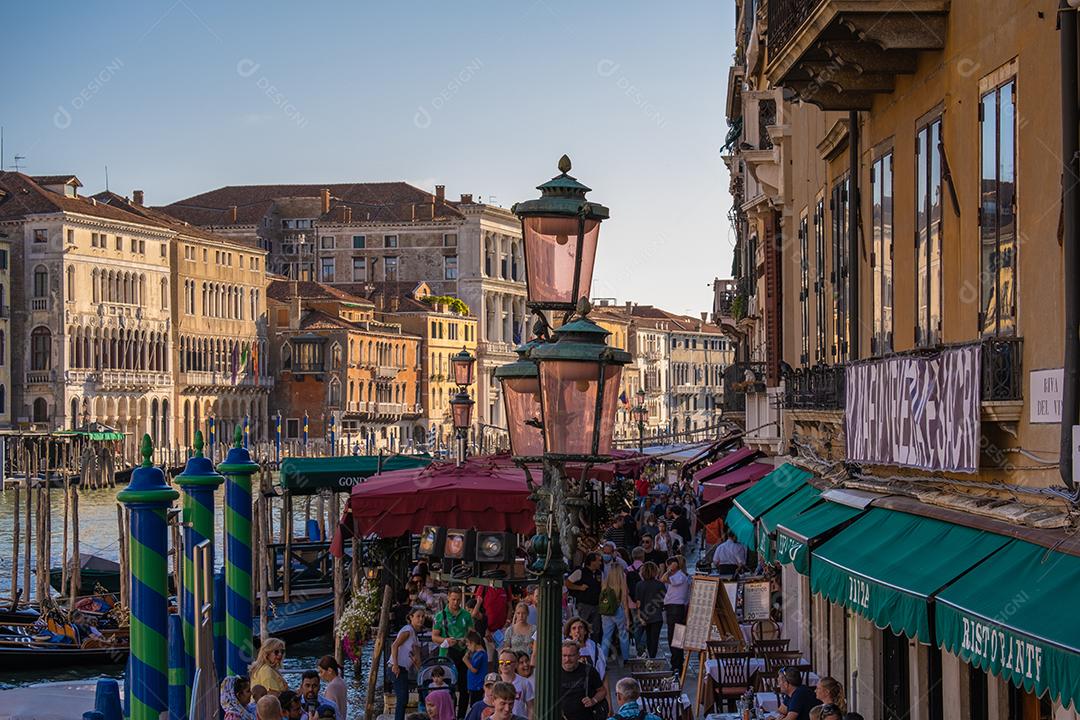 Vista das fachadas de edifícios antigos pitorescos no Grande Canal, gôndolas e barcos em Veneza. Dia de verão ensolarado com céu azul.