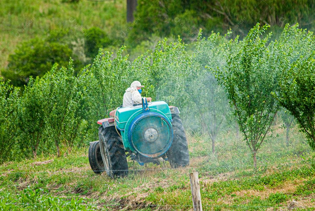 Agricultor batendo veneno em seu plantio plantação
