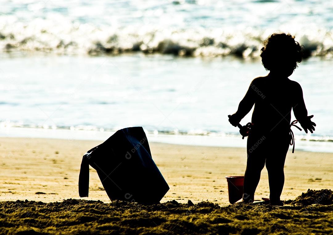 Criança brincando na praia areia mar