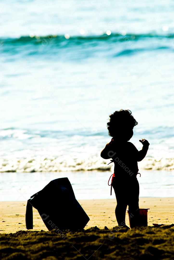 Criança brincando na praia areia mar