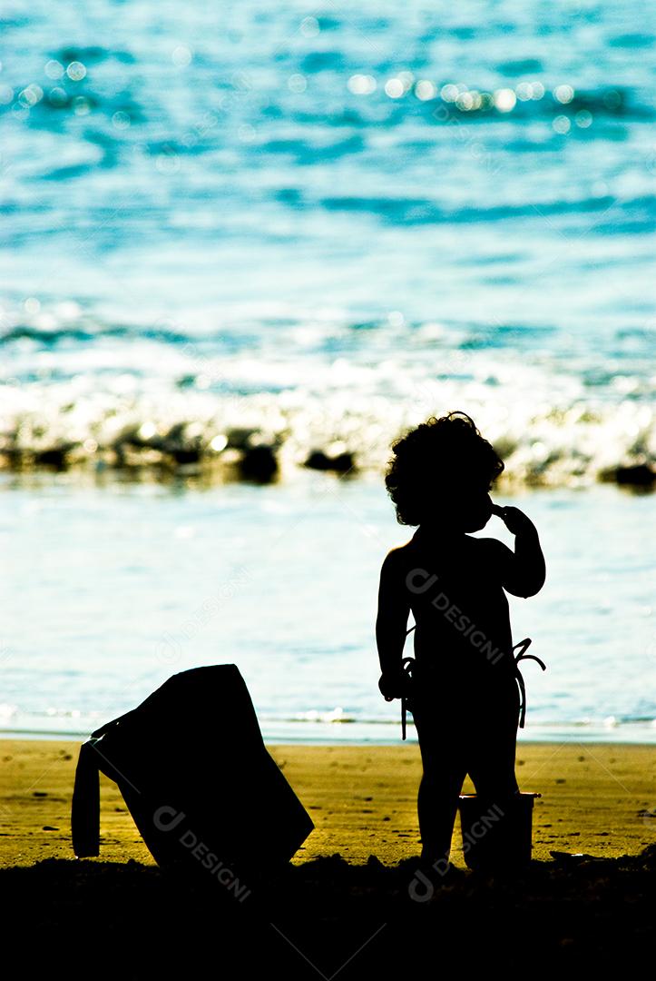 Criança brincando na praia areia mar