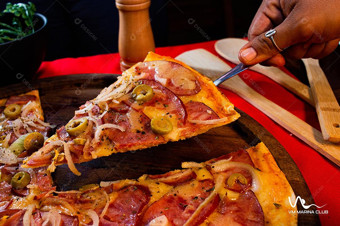Prato com fatia de pizza em mesa ao lado tabua com pizza